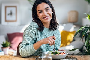 Woman smiling while eating lunch at home