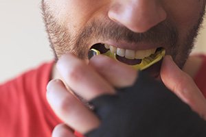 Closeup of man putting on mouthguard